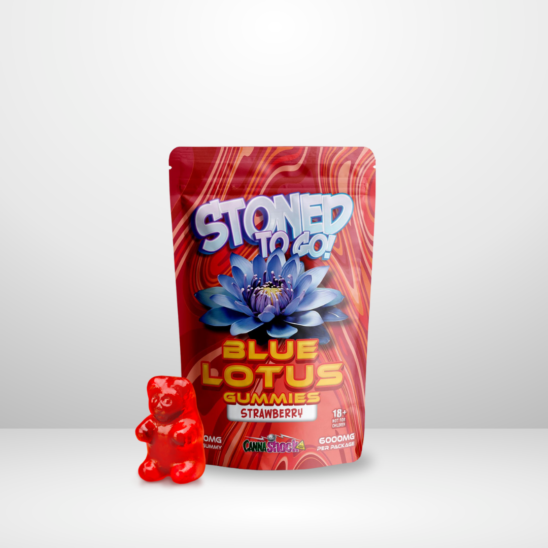 En röd gummibjörn står bredvid en Cannashock Blå Lotus Godis 6000mg-påse med en blå lotusblommagrafik, märkt "Stoned to Go!" - ett unikt tårtdekorationsalternativ.