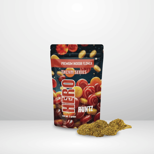 En färgglad, återförslutningsbar Hero-påse märkt THCNM Buds 50% 5g står upprätt, med två premiumknoppar som visas på framsidan mot en vanlig vit bakgrund.