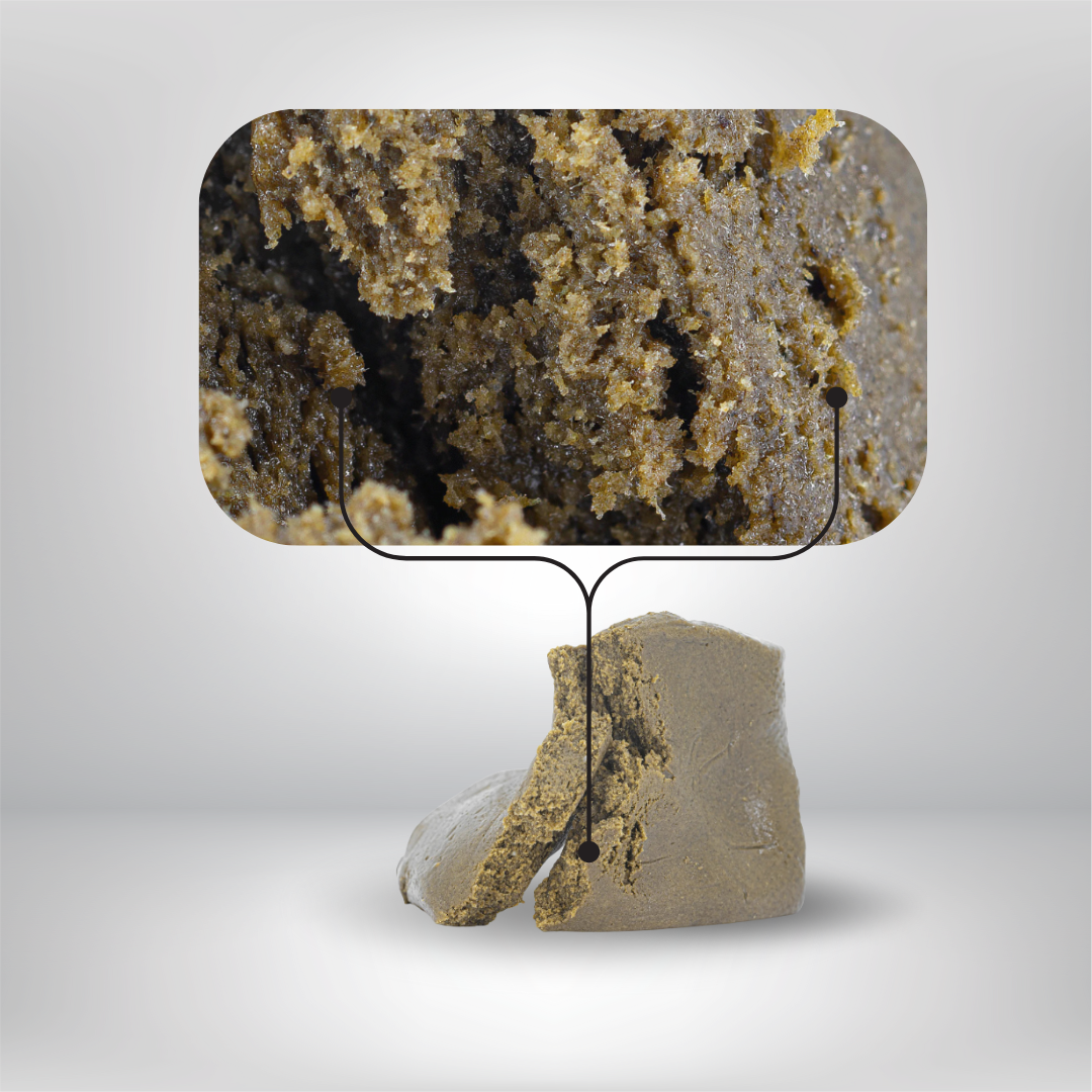 En bit av Partybolagets Dry Static THCA 5g 30% Hash visas på en grå yta, med en förstorad infälld del som visar dess granulerade inre - vilket understryker dess premiumhantverk och EU-godkända hampaursprung. Linjer förbinder infällningen för fokus.